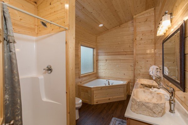 Bathroom with a jacuzzi and shower at Splash Mountain Lodge a 4 bedroom cabin rental located in Gatlinburg