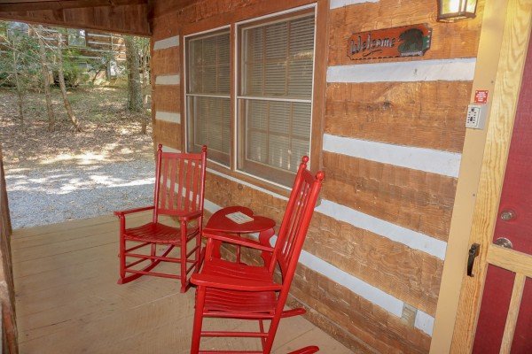 Red rocking chairs on the covered front porch at Little Bear, a 1 bedroom cabin rental located in Pigeon Forge