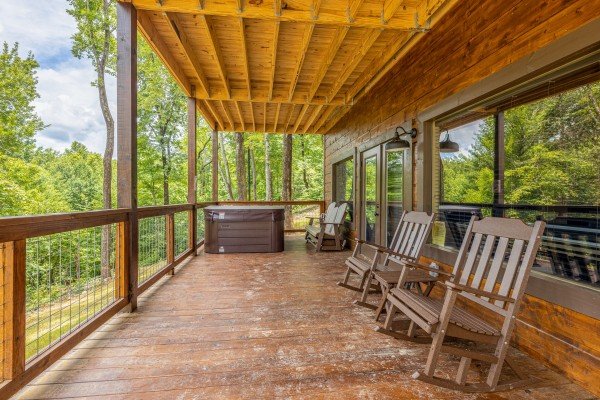Deck seating with hot tub at Heavenly Daze, a 4 bedroom cabin rental located in Pigeon Forge