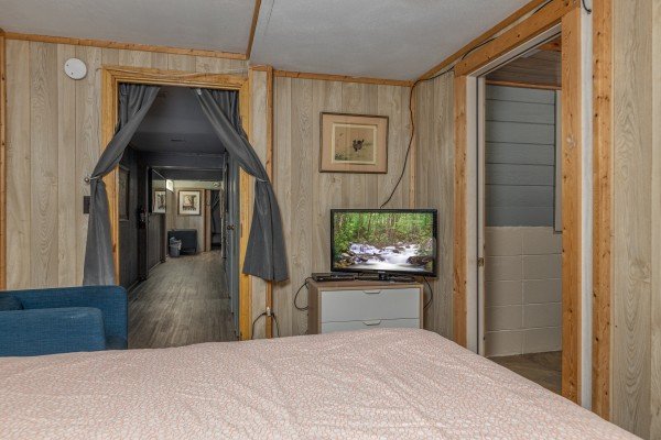 TV and dresser in a bedroom at Terrace Garden Manor, a 13 bedroom cabin rental located in Gatlinburg