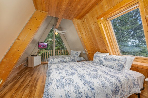 Bedroom with two beds, TV, and a balcony at Terrace Garden Manor, a 13 bedroom cabin rental located in Gatlinburg