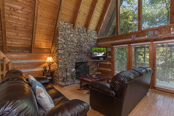 Living room with stone fireplace and TV at Soaring Heights, a 3 bedroom cabin rental located in Gatlinburg