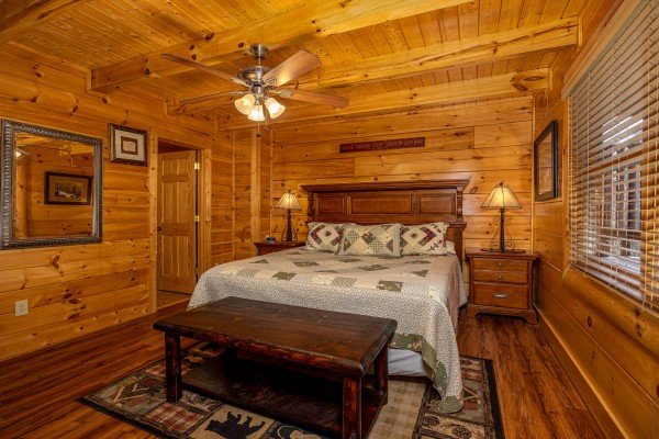 Bedroom with king sized bed and bench at Bearfoot Memories, a 2-bedroom cabin rental located in Pigeon Forge