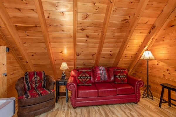 Couch and recliner in the game loft at Bearfoot Memories, a 2-bedroom cabin rental located in Pigeon Forge