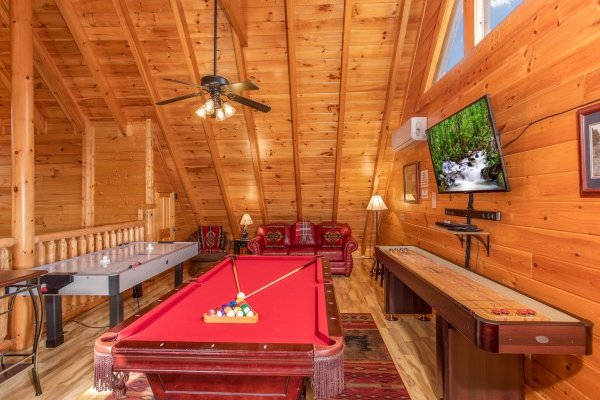 Red felt pool table, air hockey, table, and shuffle board at Bearfoot Memories, a 2-bedroom cabin rental located in Pigeon Forge