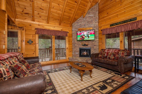 Living room fireplace and tv at Bearfoot Memories, a 2-bedroom cabin rental located in Pigeon Forge