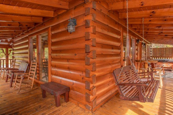 Porch swing on the wraparound covered deck at Bearfoot Memories, a 2-bedroom cabin rental located in Pigeon Forge