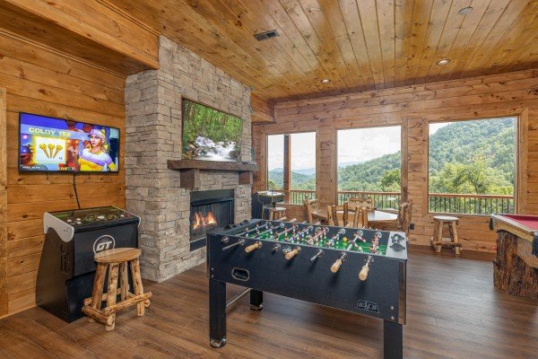 Game room with foosball, Golden Tee, fireplace, and TV at Black Bears & Biscuits Lodge, a 6 bedroom cabin rental located in Pigeon Forge