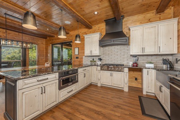 Kitchen with white cabinets and black appliances at Black Bears & Biscuits Lodge, a 6 bedroom cabin rental located in Pigeon Forge
