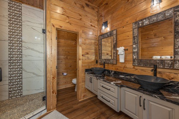 Bathroom with double vanity sinks and a large shower at Black Bears & Biscuits Lodge, a 6 bedroom cabin rental located in Pigeon Forge