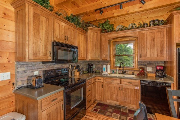 Kitchen with black appliances and stone back splash at Mountain Adventure, a 2 bedroom cabin rental located in Pigeon Forge