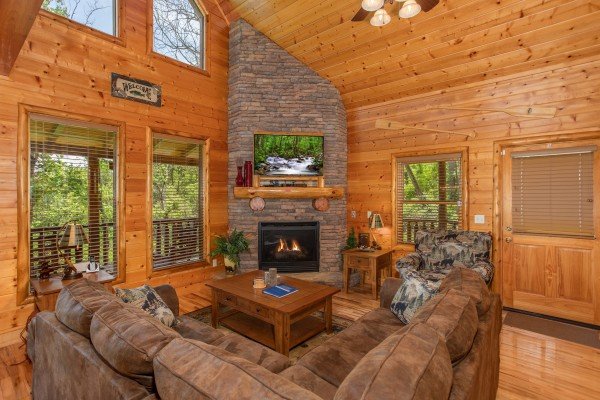 Living room with stone fireplace and TV at Mountain Adventure, a 2 bedroom cabin rental located in Pigeon Forge