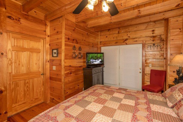 Bedroom with a dresser, TV, and deck access at Granny D's, a 2 bedroom cabin rental located in Pigeon Forge