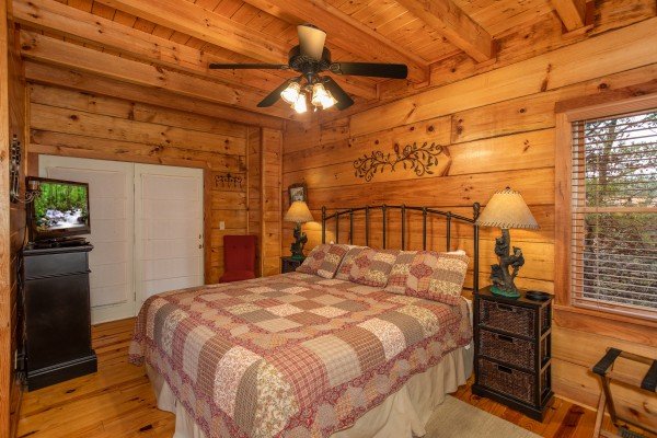 Bedroom on the main floor with a TV, dresser, and deck access at Granny D's, a 2 bedroom cabin rental located in Pigeon Forge
