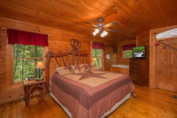 Bedroom with log bed, dresser, and TV at Cabin Sweet Cabin, a 1 bedroom cabin rental located in Gatlinburg