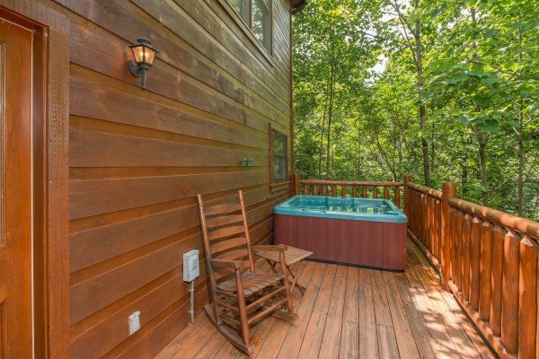Rocking chair and hot tub on the deck at Cabin Sweet Cabin, a 1 bedroom cabin rental located in Gatlinburg