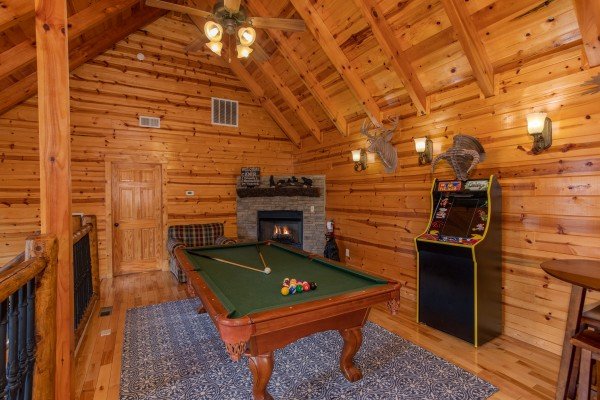 Fireplace, pool table, and arcade game at Majestic Views, a 3 bedroom cabin rental located in Pigeon Forge