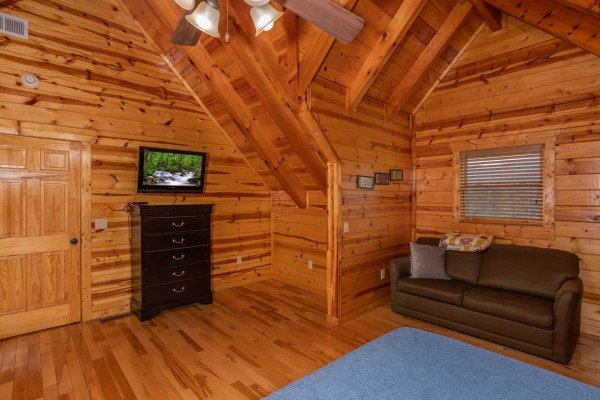 Sleeper sofa, dresser, and tv in the loft at Majestic Views, a 3 bedroom cabin rental located in Pigeon Forge