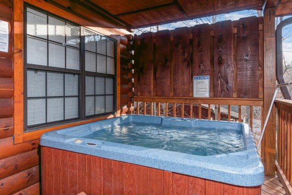 Hot tub on a covered porch at A Beary Cozy Escape, a 1 bedroom cabin rental located in Pigeon Forge