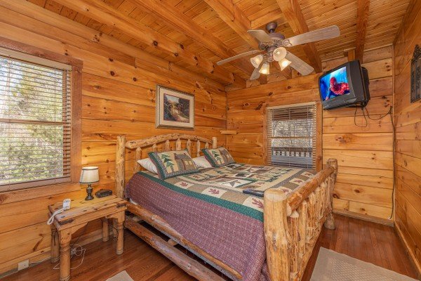 Bedroom with night table, lamp, and TV at Smoky Bears Creek, a 2 bedroom cabin rental located in Pigeon Forge