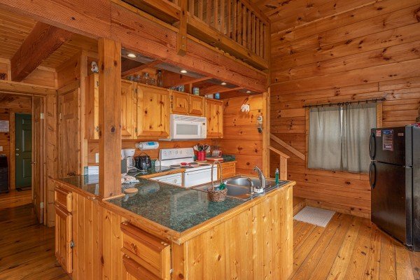 Kitchen with white appliances at Licklog Hollow, a 1 bedroom cabin rental located in Pigeon Forge
