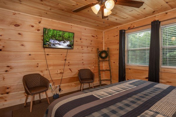 Wall mounted TV, two chairs, and a corner shelf at Always Dream'n, a 6 bedroom cabin rental located in Pigeon Forge