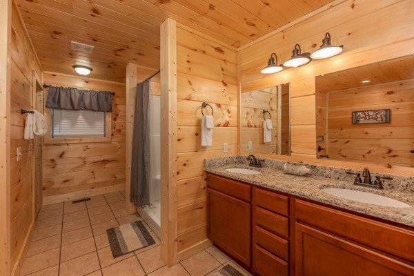 Bathroom with double vanity sink and shower at Always Dream'n, a 6 bedroom cabin rental located in Pigeon Forge