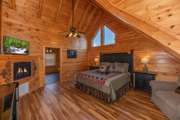 Loft bedroom with fireplace and TV at Bear Bottom Retreat, a 4 bedroom cabin rental located in Pigeon Forge