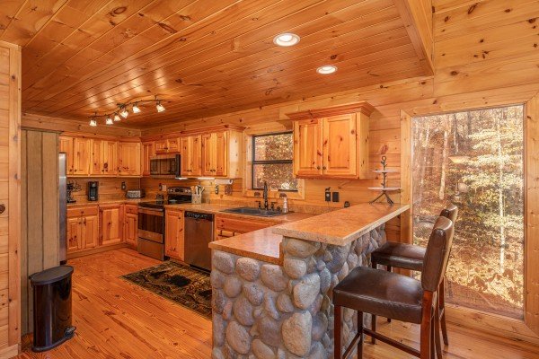 Kitchen with stainless steel appliances and breakfast bar at All Hours, a 2 bedroom cabin rental located in Pigeon Forge