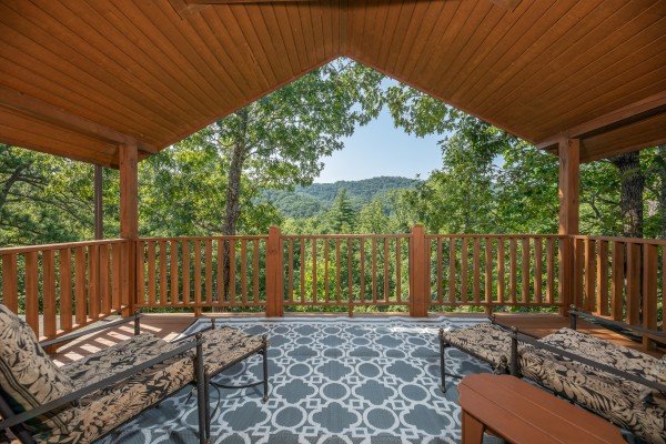 Loft deck with wooded mountain views and chaise lounge chairs at Majestic Mountain, a 4 bedroom cabin rental located in Pigeon Forge