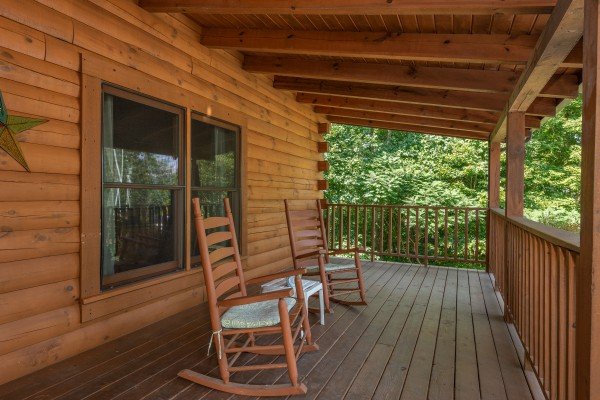 Rocking chairs on a covered deck at Majestic Mountain, a 4 bedroom cabin rental located in Pigeon Forge
