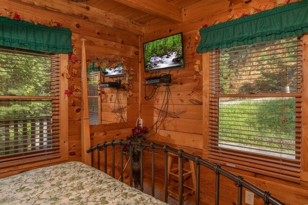 bedroom with wall mounted television at angel's majestic view a 3 bedroom cabin rental located in pigeon forge