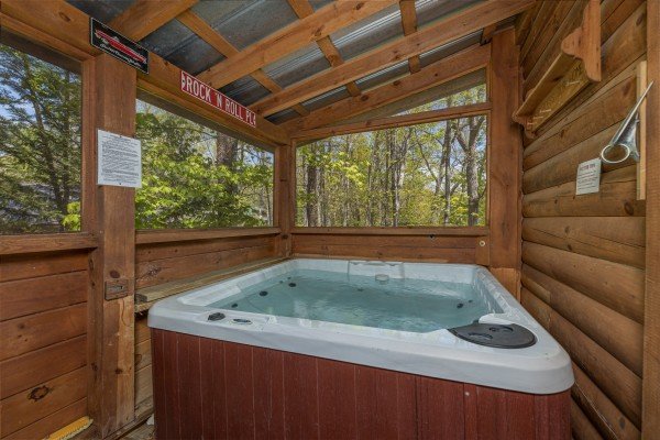 Hot tub on a covered deck at Rock Around the Clock, a 1 bedroom cabin rental located in Pigeon Forge