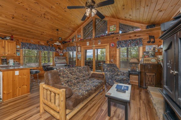 Living room futon with kitchen at Rock Around the Clock, a 1 bedroom cabin rental located in Pigeon Forge