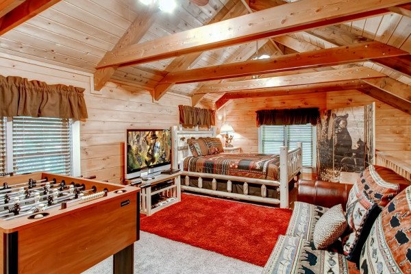 Loft with custom bed, large TV, and foosball table at Creekside Comfort, a 3-bedroom cabin rental located in Pigeon Forge