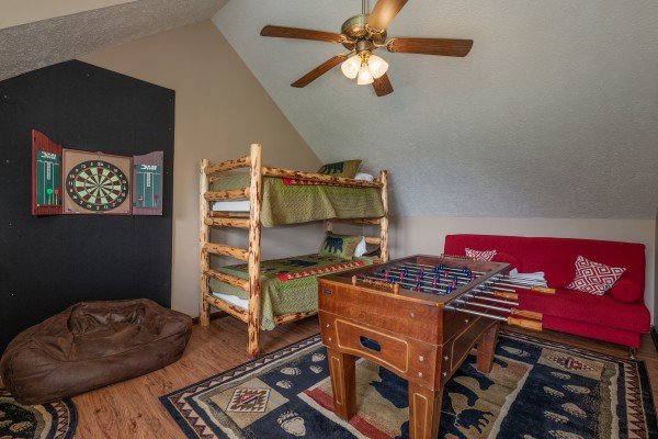 Game loft with dart board, foosball, bunk beds, and futon at Misty Mountain Sunrise, a 3 bedroom cabin rental located in Pigeon Forge
