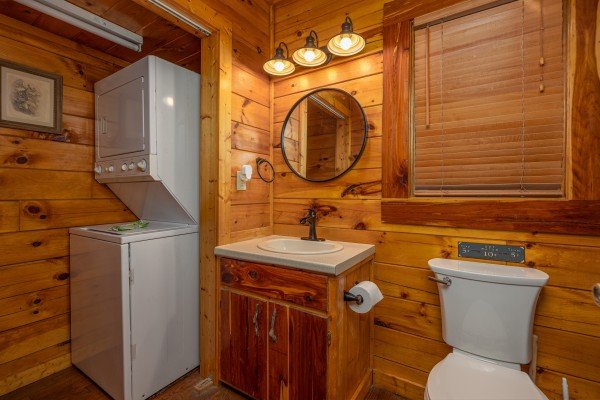 Stacked washer and dryer in a bathroom at Silver Creek Cabin, a 1 bedroom cabin rental located in Pigeon Forge